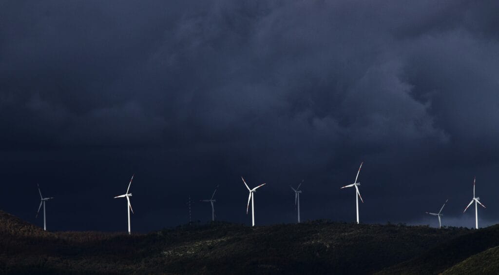 Wind turbines on a distant horizon under dark skies